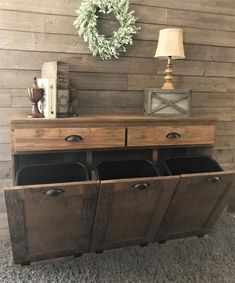 an old dresser with two bins and a wreath on the wall in front of it