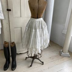 Hello and welcome to the Textile Trunk! Please follow us on Instagram, we are @textiletrunk This gorgeous textile is French and dates from the early 1900s . This petticoat ? skirt? has gorgeous lace trim and detailing throughout. This is a fairly stiff skirt, featuring layers of muslin and cotton. It buttons at the waist and has snaps to hold it closed, although one is missing (see condition details). I truly love this piece, and it could be a beautiful addition to your historic wardrobe! ~ GORG Vintage White Lace Petticoat, White Lace Vintage Bottoms, White Vintage Lace Bottoms, Vintage Lace Petticoat With Ruffles, Vintage Petticoat With Attached Cancan For Spring, Vintage Petticoat With Attached Cancan For Summer, Vintage Dress With Gathered Tiered Skirt, Vintage Gathered Skirt For Wedding, Vintage White Lace Bottoms