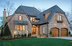 a large brick house with two garages on the front and one story above it