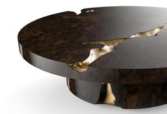 an unusual coffee table made out of wood and gold leaf detail on the top,