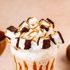 a glass filled with ice cream and marshmallows on top of a table