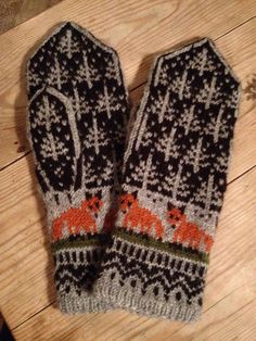 two mittens sitting on top of a wooden floor