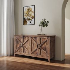 a wooden sideboard sitting on top of a hard wood floor next to a window