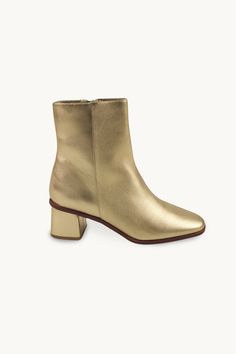 These ankle boots are crafted from high-quality leather in a metallic gold hue. They feature a side zipper closure, a low heel, and a sleek design. Designed for a bold and stylish look. Use our virtual size assistant to find your perfect fit. Unlock Screen, Metallic Boots, Ankle Heels, Tiny Cottons, High Quality Leather, Metallic Gold, Low Heels, Side Zipper, Sleek Design