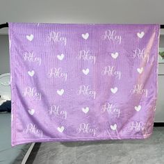 a purple banner with white hearts and the words happy on it hanging from a wall