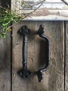 an old door handle on the side of a wooden building with vines growing out of it