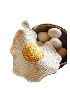 an egg in a knitted bag next to eggs