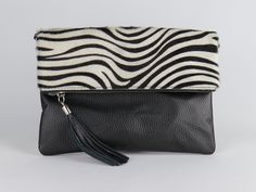 This Zebra print purse is made of soft black Italian genuine pebbled leather.  Top of this real leather handbag feature hide which is adorned with a Zebra animal print.  The hardware of these Zebra print purses is high-quality silver chrome. This real leather purse comes with a detachable and adjustable long strap, which can be adjusted to a shoulder length or a crossbody.  The inside of this Zebra print handbag is fabric lined in beige colour, it also features a small zipped pocket for smaller this such as bank cards, coins, keys etc. The back of the animal print bag also has a small zipped pocket.  This leather animal print bag for women is large enough for phones, wallets, makeup or even a small water bottle.  Dimensions: 27 cm (L) x 2 cm (W) x 18 cm (H) Dimensions: 10.6 inches (L) x 0. Black Bag With Animal Design For Everyday Use, Black Animal Design Bag For Everyday Use, Black Shoulder Bag With Animal Design For Everyday Use, Black Bags With Animal Design For Everyday Use, Leather Bags With Animal Design For Everyday Use, Black Shoulder Bag With Animal Design For Daily Use, Rectangular Leather Shoulder Bag With Animal Design, Leather Satchel Shoulder Bag With Animal Design, Black Animal Design Satchel Bag