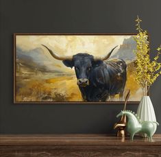 a painting of a bull is on the wall next to a vase with yellow flowers