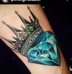 a blue diamond with a crown on it's arm is featured in this tattoo design