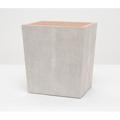 a white square vase sitting on top of a table