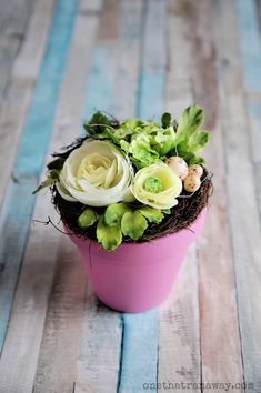 a pink pot with flowers and eggs in it