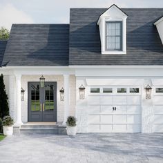 a white house with black shingles and two garage doors on the front door is shown