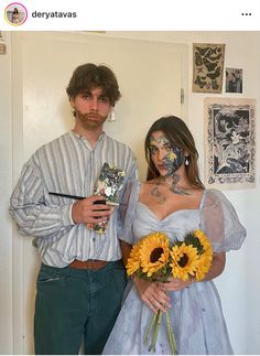 a man and woman with face paint standing next to each other holding sunflowers