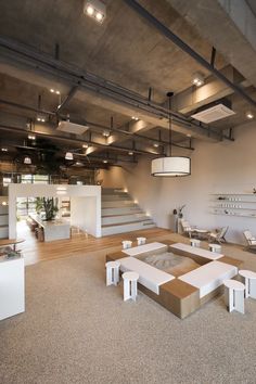 the interior of a modern office building with stairs and tables in front of an open floor plan