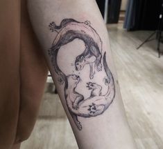 a person with a tattoo on their arm holding a cat and another animal in the shape of a circle