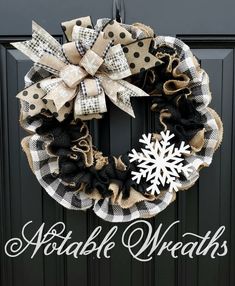 a black and white wreath with snowflakes hanging from it's front door