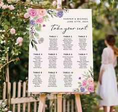 a sign with flowers on it sitting in front of a wooden easel