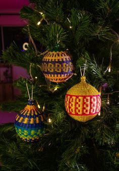 three ornaments are hanging on the christmas tree