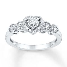 a white gold engagement ring with diamonds on the band and an oval shaped center stone