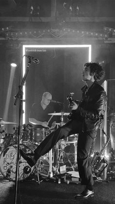 a black and white photo of a man on stage