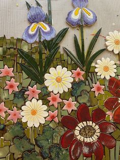 some flowers and plants made out of mosaic tiles