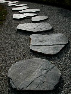 several stepping stones are lined up on the gravel