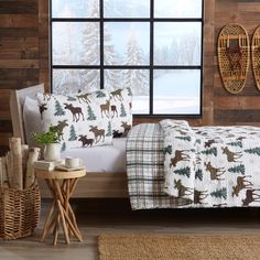 a bed sitting in a bedroom next to a window covered in deer and pine trees