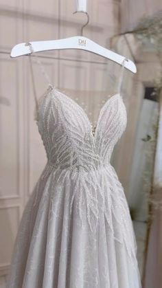 a white wedding dress hanging on a hanger