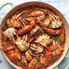 a pan filled with seafood and sauce on top of a table