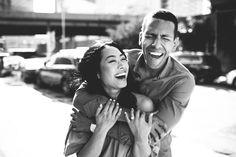 a man and woman are laughing together on the street