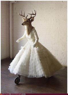 a black and white photo of a woman in a dress with antlers on her head