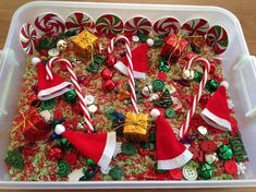 a tray filled with candy canes and christmas decorations