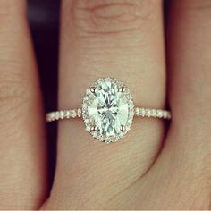 a woman's hand with a diamond ring on it and an engagement band around her finger