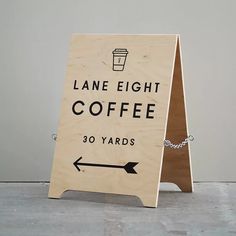 a wooden sign that says lane eight coffee 30 yards and an arrow pointing to the right