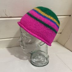 Most of this hat is bright, almost neon pink, with stripes of green and mustard. The end result has a distinctive visual energy to it, as the colors interact with one another in an unusual way. The bottom of the hat has a rolled brim, and the top is smooth and rounded. This hat is structured and handmade. It was knit and felted by hand using 100% secondhand wool yarn in a smoke-free environment. This hat is sized for an adult and suitable for all genders. Enjoy! The hat will arrive in 100% compo Playful Multicolor Short Brim Hat, Fun Green Hat One Size, Funky Multicolor Hat With Curved Brim, Multicolor Brimmed Cloche Hat, Funky Green Adjustable Hat, Adjustable Funky Green Hat, Playful Multicolor Hat, Playful Multicolor Cap, Funky Multicolor Cap