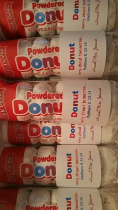 four donuts are stacked on top of each other in plastic wrapper containers with red and white labels