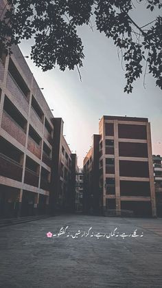 an empty parking lot in front of two buildings with arabic writing on the side of it