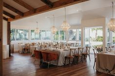 an empty dining room with tables and chairs set up for formal function or dinner party