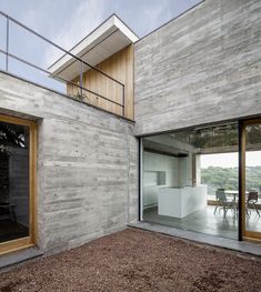 an open room with sliding glass doors leading to the dining area and outside space that is made out of concrete