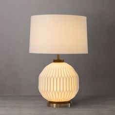 a table lamp with a white shade on the base and a light bulb attached to it