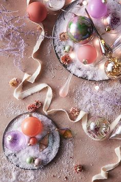 two plates filled with different types of ornaments on top of a table covered in snow