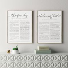 two posters on the wall above a white cabinet with books and a potted plant