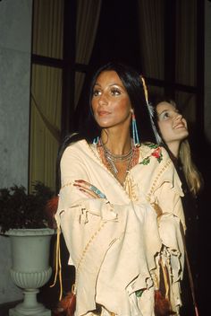 two women in native clothing standing next to each other