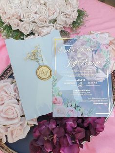 two wedding cards on a plate with flowers