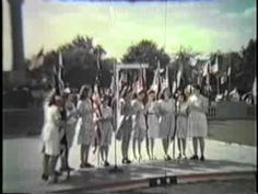 a group of people standing on top of a stage with flags in front of them