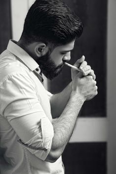 a man is brushing his teeth with an electric toothbrush while standing in front of a mirror