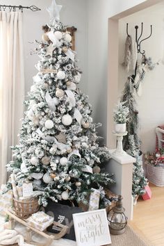 a decorated christmas tree in a living room with white and silver decorations on the top