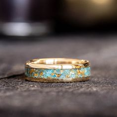 two wedding bands with gold and turquoise paint on them