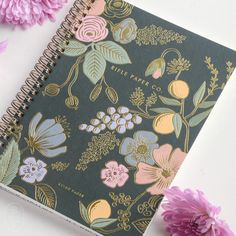 a spiral notebook with flowers and leaves on it